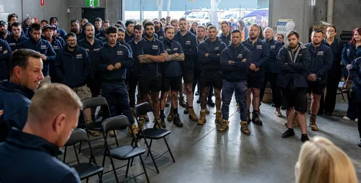 in the warehouse with technicians team meeting